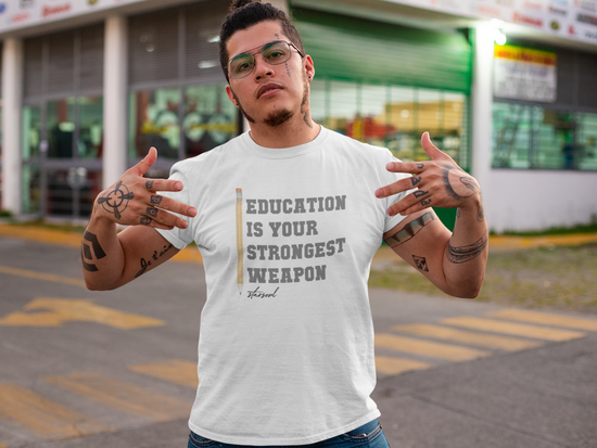 Man wearing a shirt that says: EDUCATION IS YOUR STRONGEST WEAPON,  all proceeds go to kids in low poverty schools