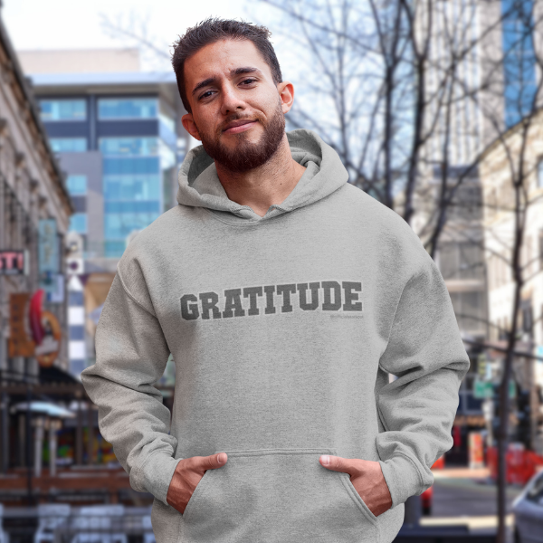 Man wearing a gray hoodie with 'GRATITUDE' text all proceeds feeding veterans