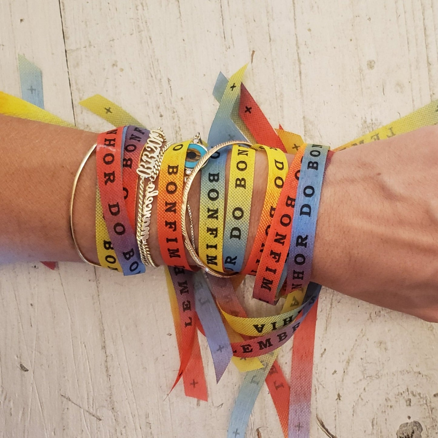Charity t-shirt subscription box. All proceeds from these bracelet will support the cause of the month at time of purchase. Brazilian bonfim bracelet for wishes, good luck, karma. All proceeds go to charity. Photo: rainbow colored bracelets