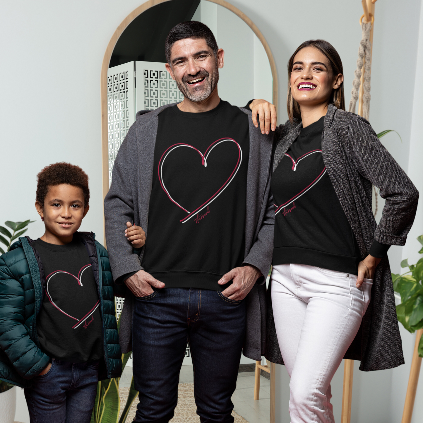family wearing black sweatshirt with double red white heart design benefitting heart disease