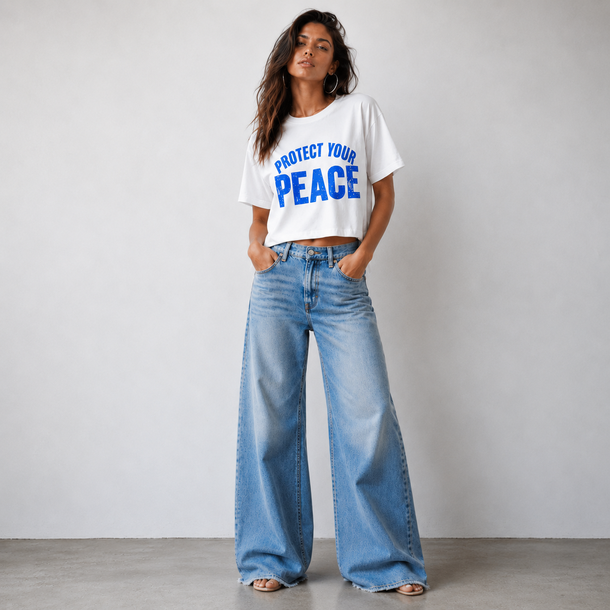 Woman wearing the Protect Your Peace vintage boxy graphic tee in white with cobalt blue distressed lettering.
