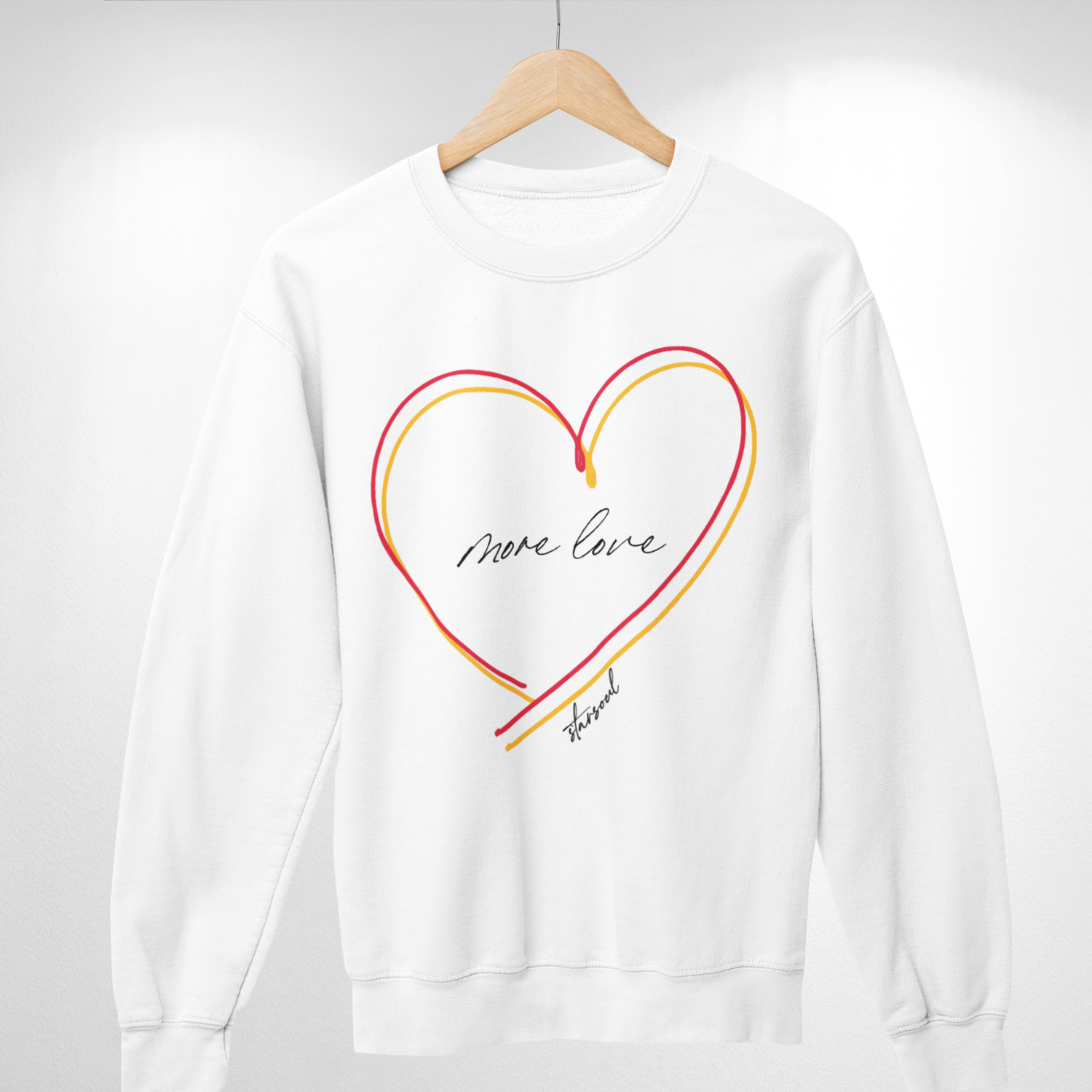 white sweatshirt with yellow and red heart (text: more love).Every purchase from the #KCstrong collection donates 100% of the proceeds to the Kansas City Strong emergency fund created by the Chiefs and the United Way of Kansas City.